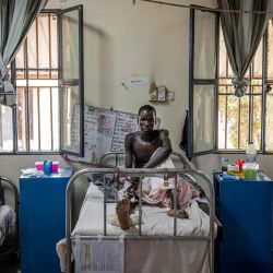 Mading Akol, recibe tratamiento en su cama de hospital por heridas de bala en la pierna en una sala del Hospital Militar de Juba, atendida por el Comité Internacional de la Cruz Roja (CICR). La escasa atención médica existente en Sudán del Sur depende casi en su totalidad de donantes extranjeros, y más del 80% está cubierta por ONG. Mientras el país de África Oriental se sumerge nuevamente en la guerra civil, un informe reciente de las Naciones Unidas documentó cómo los líderes del país han despilfarrado y robado miles de millones de dólares en ingresos petroleros. En consecuencia, ONG como el Comité Internacional de la Cruz Roja (CICR) y Médicos Sin Fronteras (MSF) tienen que paliar las carencias.  | Foto:LUIS TATO / AFP