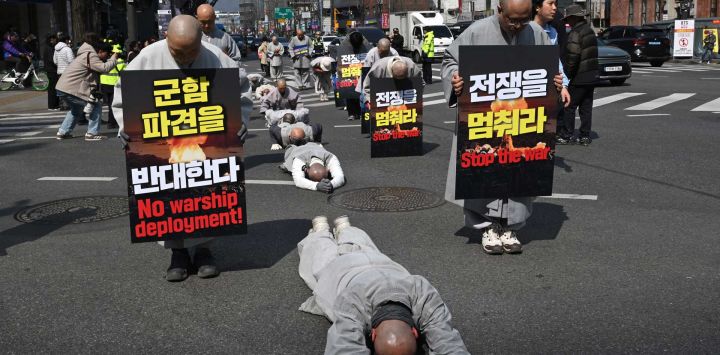 Monjes budistas surcoreanos realizan reverencias completas mientras marchan hacia la embajada de Estados Unidos durante una protesta contra la guerra contra Irán en Seúl.