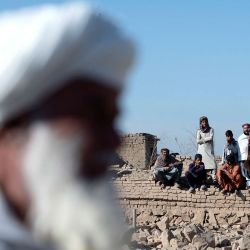 Habitantes afganos se sientan entre casas dañadas en el lugar de un ataque aéreo pakistaní nocturno, en una zona residencial de Pol-e-Charkhi, en las afueras de Kabul. Las autoridades afganas informaron ese mismo día que Pakistán había llevado a cabo nuevos ataques contra Kabul y las provincias fronterizas, causando la muerte de cuatro personas en la capital. | Foto:WAKIL KOHSAR / AFP