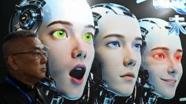 Un hombre se encuentra junto a un cartel que muestra robots imitando expresiones humanas, de la empresa Shenzhen Xiaoquan Technology, durante la Exposición Internacional de Aplicaciones de IA e Innovación Robótica celebrada en Pekín.