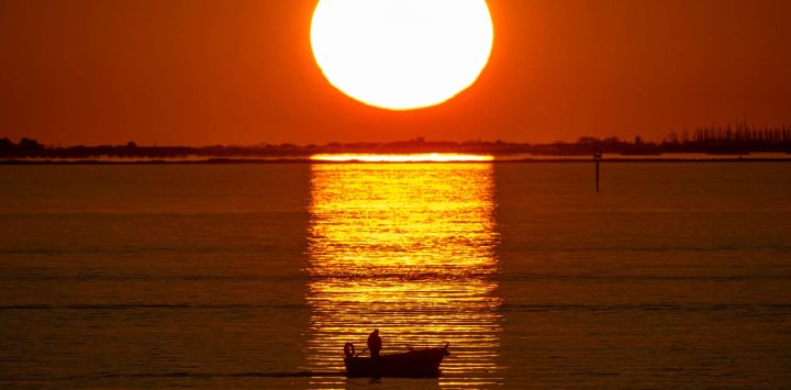Esta fotografía, tomada desde Port de Bouc, muestra un barco al atardecer en el Grand Port Maritime de Marseille-Fos, en Fos-sur-Mer, frente a la costa mediterránea del sur de Francia.