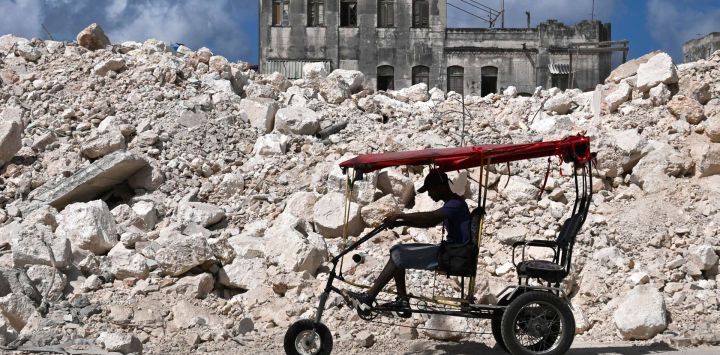 Un hombre pasea en bicicleta frente a los escombros de la Escuela Nacional de Diseño en La Habana. Cuba se apresuró a restablecer el suministro eléctrico tras un apagón nacional que afectó a la isla, gobernada por el Partido Comunista, justo cuando el presidente estadounidense Donald Trump proclamó que la "tomaría". 