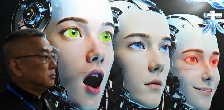 Un hombre se encuentra junto a un cartel que muestra robots imitando expresiones humanas, de la empresa Shenzhen Xiaoquan Technology, durante la Exposición Internacional de Aplicaciones de IA e Innovación Robótica celebrada en Pekín.
