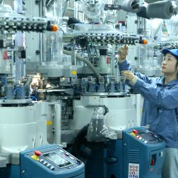 Un trabajador labora en la línea de producción de una empresa de calcetines, en el distrito de Qingdao, en la provincia de Shandong, en el este de China. | Foto:Xinhua/Liang Xiaopeng