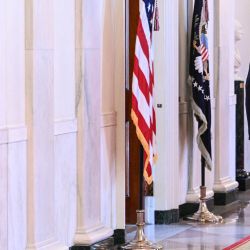 El presidente estadounidense Donald Trump camina por el Salón de la Cruz a su llegada a la ceremonia de entrega del Trofeo del Comandante en Jefe al equipo de fútbol americano Navy Midshipmen de la Academia Naval de los Estados Unidos en el Salón Este de la Casa Blanca en Washington, D.C. | Foto:BRENDAN SMIALOWSKI / AFP