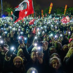 Simpatizantes alzan sus teléfonos móviles con linternas durante una protesta que conmemora el primer aniversario de la detención del alcalde de Estambul, Ekrem Imamoglu, en la plaza Sarachane de Estambul, Turquía. | Foto:Yasin Akgul / AFP