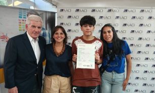 Miguel Maxwell y Josefina Rouillet con el alumno y su mamá al recibir su diploma este lunes en el Centro Comunitario Bajo Autopista.