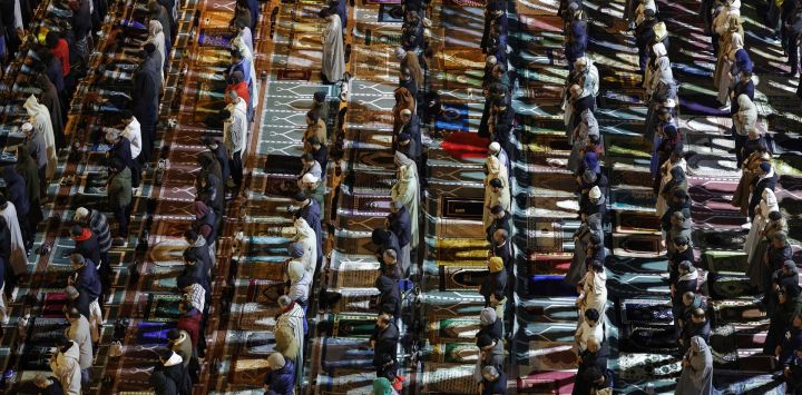 Fieles musulmanes realizan las oraciones nocturnas de Tarawih durante el mes sagrado de Ramadán, frente a la mezquita Diour Jamaa en Rabat, Marruecos.