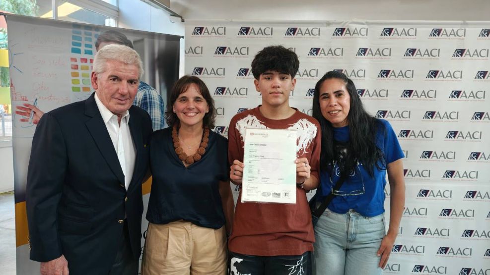 Miguel Maxwell y Josefina Rouillet con el alumno y su mamá al recibir su diploma este lunes en el Centro Comunitario Bajo Autopista.