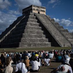 La gente se reúne para observar cómo la silueta de una serpiente se proyecta en las sombras sobre la pirámide de El Castillo en Chichén Itzá, durante el equinoccio, en el estado de Yucatán, México. El equinoccio de Chichén Itzá es un evento que ocurre dos veces al año (primavera y otoño) cuando la luz del sol y las sombras crean la ilusión de una serpiente, la deidad Kukulcán, sobre la famosa pirámide principal de Chichén Itzá. | Foto:CARL DE SOUZA / AFP