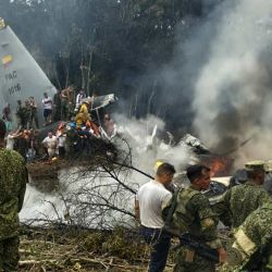 Soldados y rescatistas cerca de un avión Hércules de la Fuerza Aérea que emite una densa humareda tras estrellarse durante el despegue en Puerto Leguizamo, Colombia, cerca de la frontera sur con Ecuador. El ejército colombiano informó que se creía que unos 80 soldados habían muerto tras el accidente de un avión de transporte en el sur del país. | Foto:Daniel Ortiz / AFP