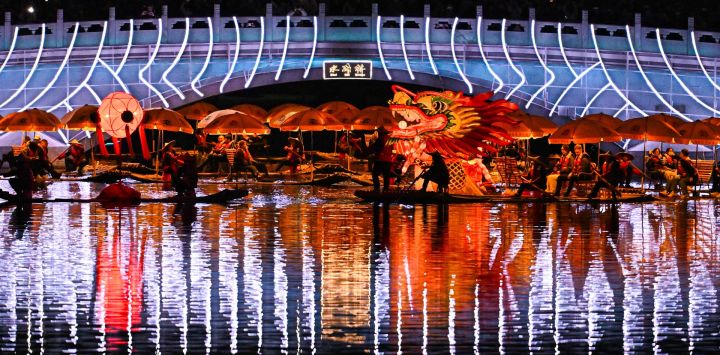 Imagen de una escena de un espectáculo folclórico en el río Liangma, en Beijing, capital de China. Con balsas de bambú unidas de un extremo a otro como un dragón dorado, el espectáculo folclórico de Yangshuo, en la región autónoma zhuang de Guangxi, en el sur de China, iluminó la noche en Beijing.