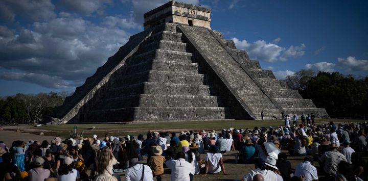 La gente se reúne para observar cómo la silueta de una serpiente se proyecta en las sombras sobre la pirámide de El Castillo en Chichén Itzá, durante el equinoccio, en el estado de Yucatán, México. El equinoccio de Chichén Itzá es un evento que ocurre dos veces al año (primavera y otoño) cuando la luz del sol y las sombras crean la ilusión de una serpiente, la deidad Kukulcán, sobre la famosa pirámide principal de Chichén Itzá.