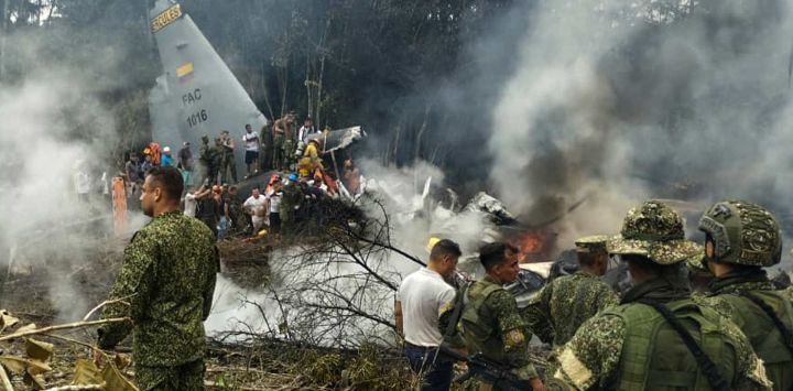 Soldados y rescatistas cerca de un avión Hércules de la Fuerza Aérea que emite una densa humareda tras estrellarse durante el despegue en Puerto Leguizamo, Colombia, cerca de la frontera sur con Ecuador. El ejército colombiano informó que se creía que unos 80 soldados habían muerto tras el accidente de un avión de transporte en el sur del país.