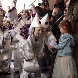 Artistas enmascarados lanzan confeti a una niña durante el último día del carnaval de la ciudad en el centro histórico de Limoux, en el sur de Francia. | Foto:Valentine Chapuis / AFP
