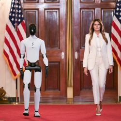 La primera dama estadounidense, Melania Trump, camina acompañada de un robot humanoide a su llegada a la Cumbre de la Coalición Global "Fomentando el Futuro Juntos" en el Salón Este de la Casa Blanca en Washington, D.C.. | Foto:Oliver Contreras / AFP
