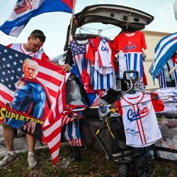 Un hombre examina banderas cubanas y ropa a la venta en la manifestación "Cuba Libre" en la ciudad de Hialeah, Florida. | Foto:Giorgio Viera / AFP