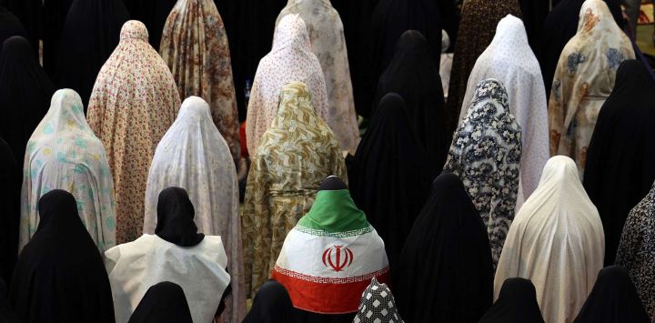 Mujeres chiítas iraníes, entre ellas una cubierta con la bandera nacional iraní, participan en las oraciones del Eid al-Fitr, que marcan el final del mes sagrado musulmán del Ramadán, en la Gran Mezquita de Mosalla en Teherán. La capital iraní ha sido objeto de bombardeos casi diarios desde que un ataque conjunto estadounidense-israelí dio inicio a la guerra el 28 de febrero, causando la muerte de altos funcionarios, incluido el líder supremo de la república islámica.