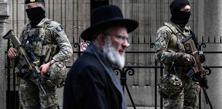 Personal militar belga armado con fusiles de asalto FN SCAR monta guardia frente a una sinagoga en el centro de Amberes, como parte de las medidas de seguridad reforzadas que Bélgica ha implementado en escuelas y sinagogas judías. El 9 de marzo de 2026, una explosión sacudió una sinagoga en la ciudad belga de Lieja antes del amanecer, causando algunos daños pero sin heridos. Esta serie de ataques contra sinagogas se produce tras el inicio de la guerra entre Estados Unidos e Israel contra Irán, un conflicto que desde entonces se ha extendido por todo Oriente Medio.