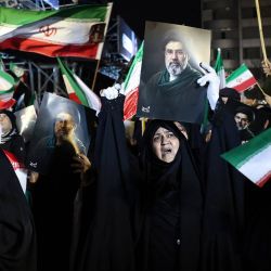 Personas ondean banderas nacionales y portan retratos del líder supremo de Irán, Mojtaba Khamenei, mientras marchan en apoyo a las fuerzas armadas iraníes en el centro de Teherán. El presidente Donald Trump está listo para "desatar el infierno" si Irán no acepta un acuerdo para poner fin a la guerra en Oriente Medio, advirtió la Casa Blanca, añadiendo que las conversaciones continuaron a pesar de que Teherán supuestamente rechazó un plan de paz propuesto por Estados Unidos. | Foto:AFP