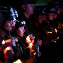 Policías militares colombianos sostienen velas durante una vigilia por las víctimas del accidente del avión Hércules de la Fuerza Aérea Colombiana en Puerto Leguizamo, Bogotá. Al menos 69 soldados y policías murieron en uno de los accidentes aéreos más mortíferos de la historia reciente de Colombia, según un nuevo recuento, que el gobierno atribuyó a una aeronave "chatarra" donada por Estados Unidos. | Foto:DANIEL MUNOZ / AFP