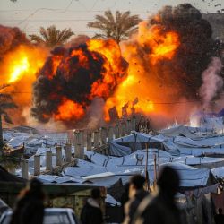 Una bola de fuego estalla tras un ataque israelí cerca de un campamento de tiendas de campaña que alberga a personas desplazadas por la guerra en Deir el-Balah, en el centro de la Franja de Gaza. La violencia ha persistido en Gaza a pesar del alto el fuego que entró en vigor el 10 de octubre, y tanto Israel como Hamás se acusan mutuamente de violaciones. | Foto:Eyad Baba / AFP