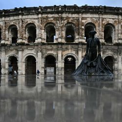 Vista exterior de la arena romana con una escultura de un torero en Nimes, Francia. | Foto:GABRIEL BOUYS / AFP