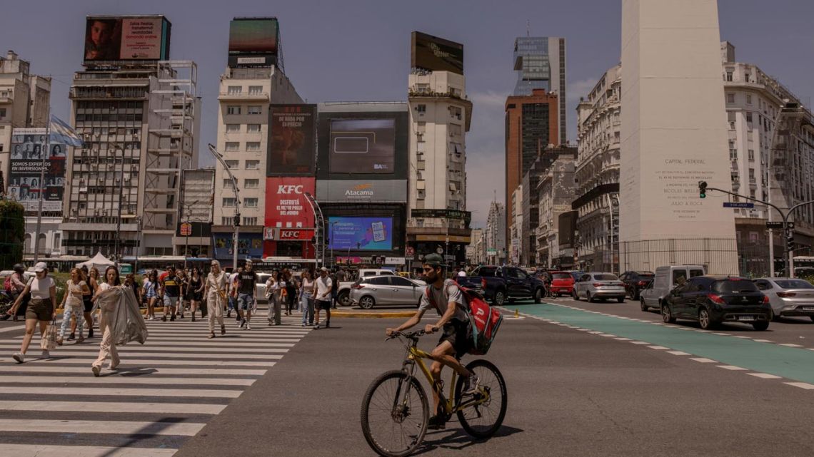 Pedestrians and traffic near the Obelisk on Avenida 9 de Julio in Buenos Aires.