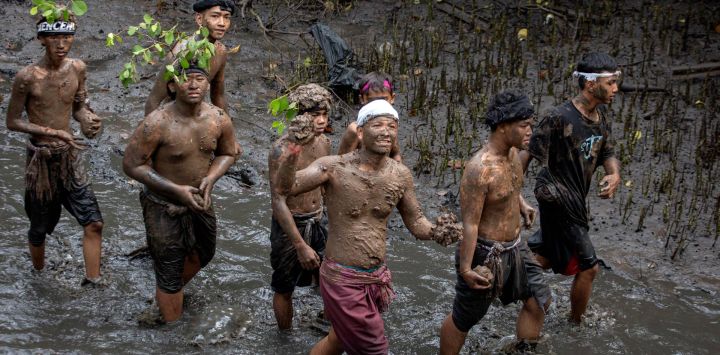 Imagen de balineses cubriendose el cuerpo con barro mientras participan en la tradición del baño de barro, conocida como Mebuug-buugan, en la aldea de Kedonganan, en la regencia de Badung, Bali, Indonesia. El Mebuug-buugan se celebra un día después de Nyepi con el objetivo de neutralizar las energías negativas.
