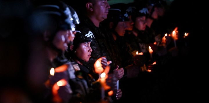 Policías militares colombianos sostienen velas durante una vigilia por las víctimas del accidente del avión Hércules de la Fuerza Aérea Colombiana en Puerto Leguizamo, Bogotá. Al menos 69 soldados y policías murieron en uno de los accidentes aéreos más mortíferos de la historia reciente de Colombia, según un nuevo recuento, que el gobierno atribuyó a una aeronave "chatarra" donada por Estados Unidos.