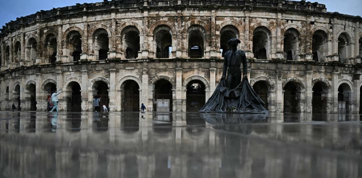 Vista exterior de la arena romana con una escultura de un torero en Nimes, Francia.