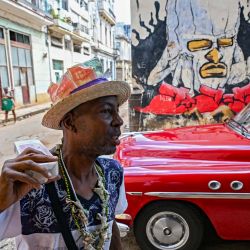 Un hombre lleva un sombrero decorado con billetes que muestran imágenes del guerrillero argentino Ernesto "Che" Guevara mientras camina por una calle de La Habana, Cuba. | Foto:YAMIL LAGE / AFP