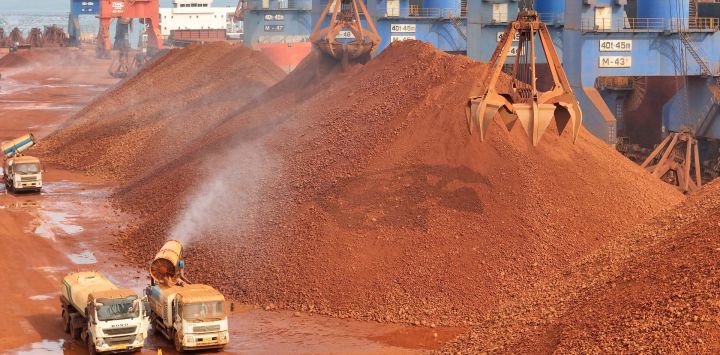 Esta fotografía muestra grúas descargando bauxita importada de Guinea en un puerto de Yantai, provincia de Shandong, al este de China.