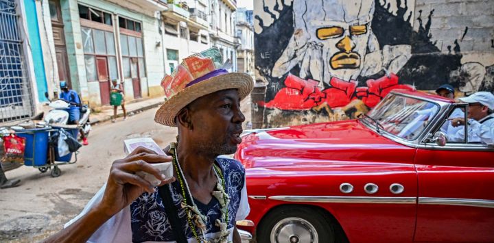 Un hombre lleva un sombrero decorado con billetes que muestran imágenes del guerrillero argentino Ernesto "Che" Guevara mientras camina por una calle de La Habana, Cuba.