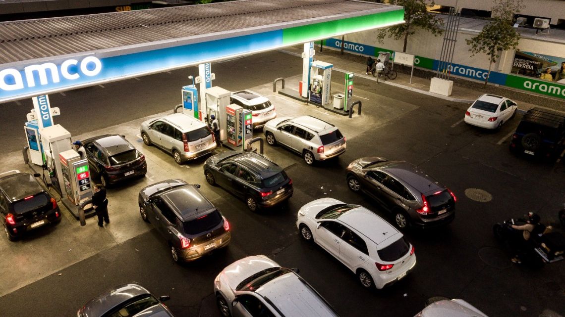 Customers wait in line to fuel vehicles at a gas station in Santiago.