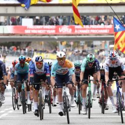 El ciclista australiano Brady Gilmore (C), del equipo NSN Cycling Team, cruza en primer lugar la línea de meta de la séptima y última etapa de la Vuelta a Cataluña 2026, una carrera de 95,1 km en Barcelona. | Foto:Josep Lago / AFP