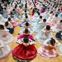 Estudiantes surcoreanas vestidas con el traje tradicional hanbok hacen una reverencia durante una ceremonia de graduación y mayoría de edad en una escuela secundaria femenina en Seúl. Alrededor de 300 estudiantes asistieron al evento, que simboliza la transición de la niñez a la adultez y tiene como objetivo inculcarles buenos modales y responsabilidad. | Foto:Jung Yeon-je / AFP
