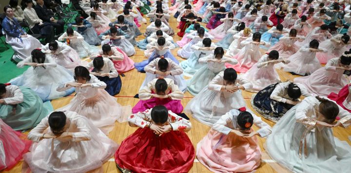 Estudiantes surcoreanas vestidas con el traje tradicional hanbok hacen una reverencia durante una ceremonia de graduación y mayoría de edad en una escuela secundaria femenina en Seúl. Alrededor de 300 estudiantes asistieron al evento, que simboliza la transición de la niñez a la adultez y tiene como objetivo inculcarles buenos modales y responsabilidad.
