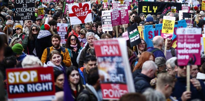 Manifestantes con pancartas y banderas participan en una marcha contra la extrema derecha, organizada por Together Alliance, en el centro de Londres, Inglaterra.