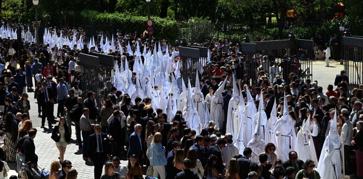 Penitentes de la hermandad de La Paz participan en la procesión del Domingo de Ramos en Sevilla. Las coloridas celebraciones de la Semana Santa en España comienzan con procesiones centenarias de fieles que portan carrozas adornadas con flores y coronadas con estatuas de Cristo o la Virgen María, que congregan a multitudes.