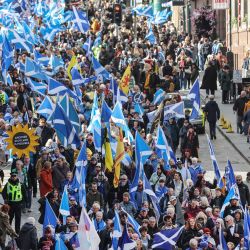 En Edimburgo, la gente ondea banderas escocesas y porta pancartas mientras marcha en apoyo a la independencia de Escocia. | Foto:Robert Perry / AFP