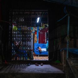 Un hombre y una mujer ven la televisión en su casa en Yangon, Birmania. | Foto:Anthony Wallace / AFP