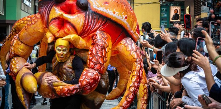 Un artista disfrazado de cangrejo baila durante el Desfile Internacional de Macao en Macao.