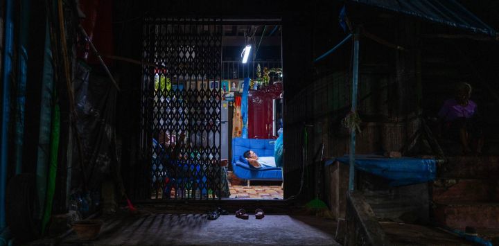 Un hombre y una mujer ven la televisión en su casa en Yangon, Birmania.