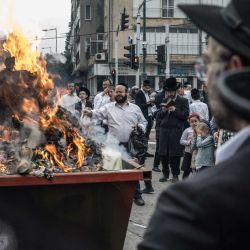 Judíos ortodoxos participan en el ritual tradicional de quema de jametz (alimentos fermentados) la mañana anterior a la Pascua judía en Bnei Brak, en el centro de Israel. La festividad judía de Pésaj, que dura ocho días, conmemora el éxodo de los israelitas de la esclavitud en Egipto y su difícil situación, absteniéndose de consumir alimentos fermentados. | Foto:MARCO LONGARI / AFP