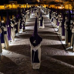 Penitentes de la Cofradía de Jesús del Vía Crucis desfilan sobre un puente durante una procesión de Semana Santa en la ciudad de Zamora, al noroeste de España. Las coloridas celebraciones de Semana Santa en España comenzaron esta semana, con procesiones centenarias de fieles que portan carrozas adornadas con flores y coronadas con estatuas de Cristo o la Virgen María, que congregan a multitudes. | Foto:Cesar Manso / AFP