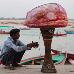 Un vendedor ambulante de aperitivos espera a los clientes a orillas del río Ganges en Meer Ghat, Varanasi, India. | Foto:NIHARIKA KULKARNI / AFP