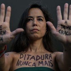 Una mujer con el cuerpo pintado con la inscripción “Dictadura nunca más” participa en una marcha silenciosa en memoria de las víctimas de la violencia estatal durante la dictadura de 1964 en São Paulo, Brasil. | Foto:NELSON ALMEIDA / AFP