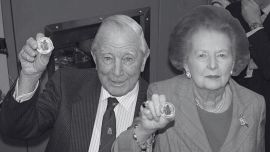 Sir Rex Hunt, el gobernador de Malvinas que fue exiliado por Galtieri en pijama, con una botella de ginebra y el retrato de la Reina