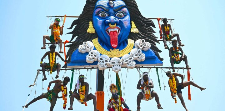Devotos tamiles suspendidos en el aire desde una grúa perforándose en ganchos de metal para honrar al dios hindú Murugan durante el festival Panguni Uthiram en Mumbai, India.